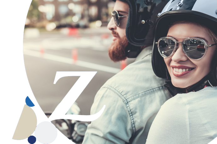 pareja con cascos y gafas de sol circulando en una moto