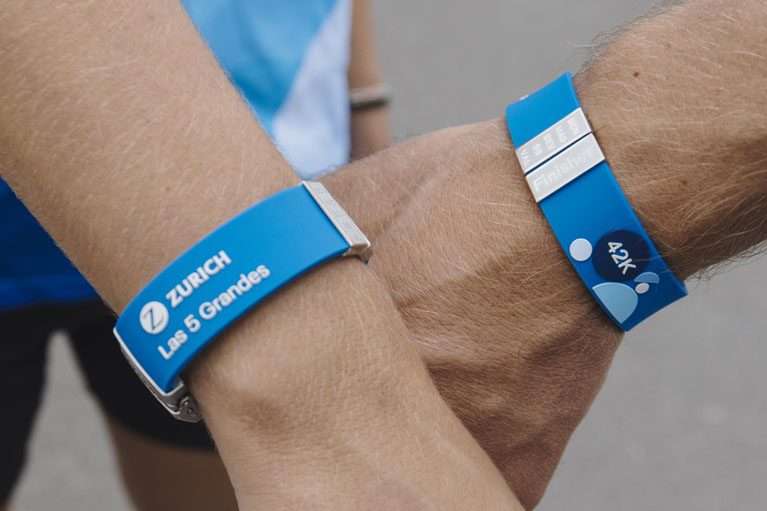 dos brazos con la pulsera conmemorativa Zurich en la muñeca